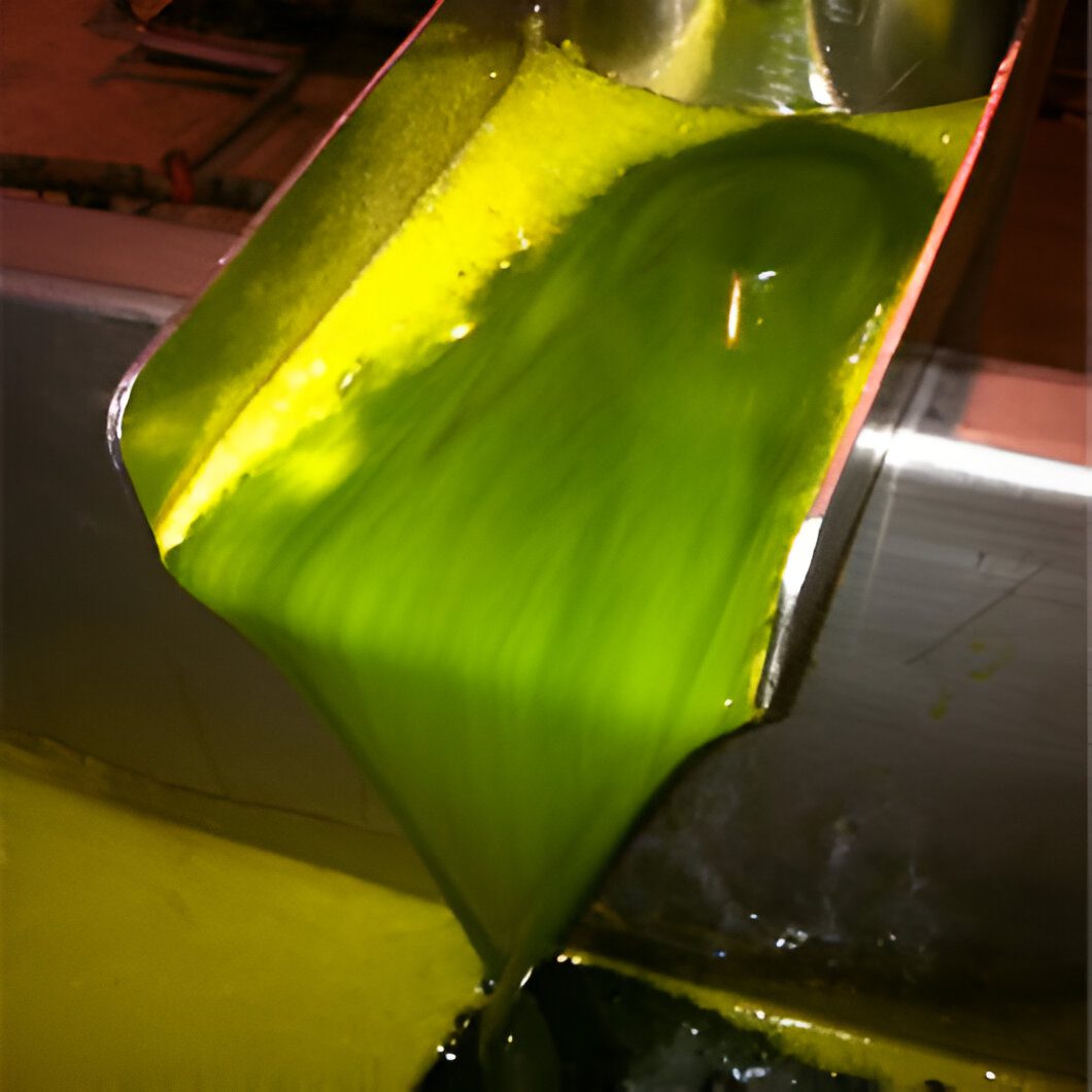 Pouring vibrant green liquid from metal chute.