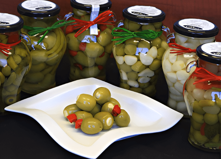 Jars of olives and garlic with plate.