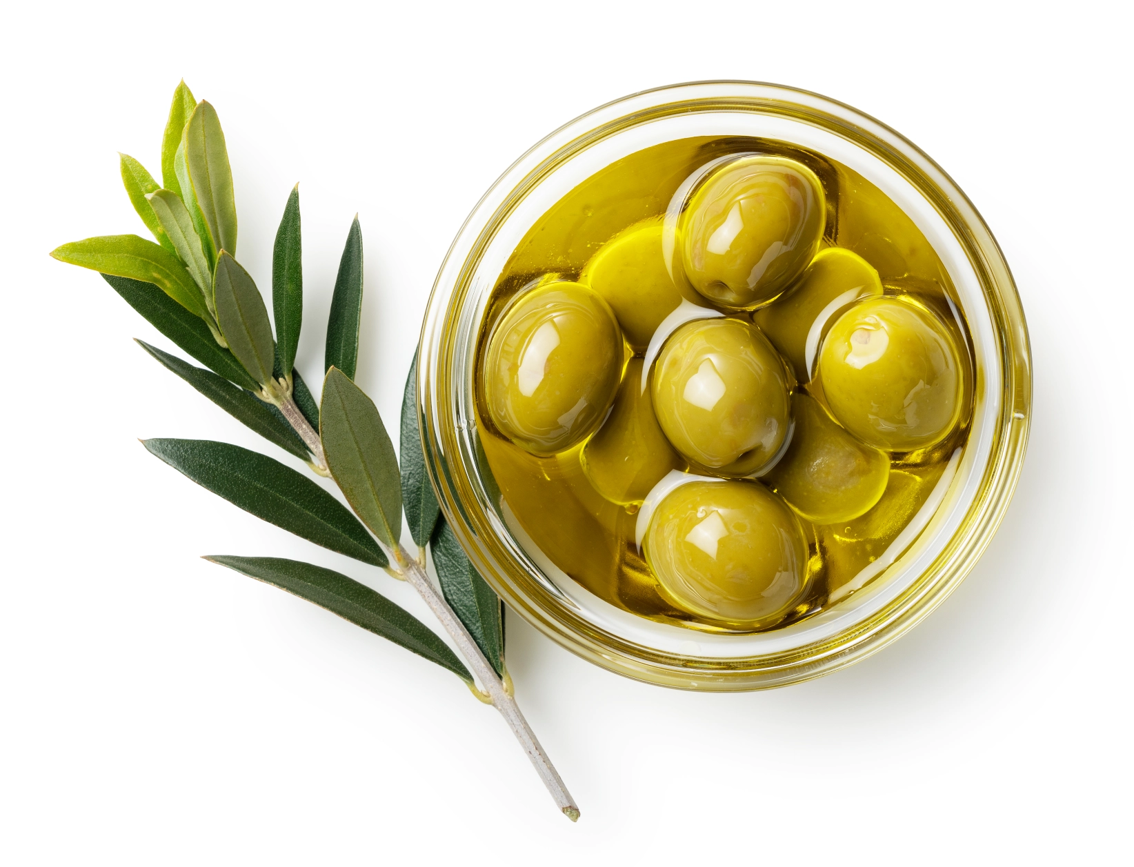 GettyImages-1353349277 Glass jar with green olives and leaves.