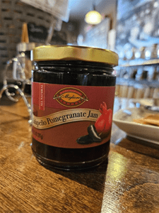 Pomegranate jam jar on wooden table.