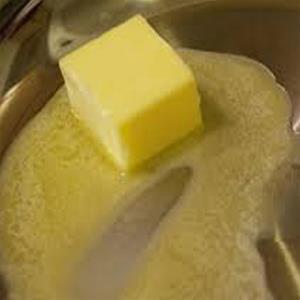 Butter cube melting in a pan.