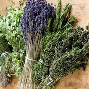 Bundles of fresh herbs on wooden surface.