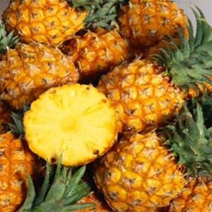 Fresh pineapples with one sliced open.