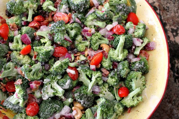 135832832 A close up of broccoli salad with tomatoes and onions